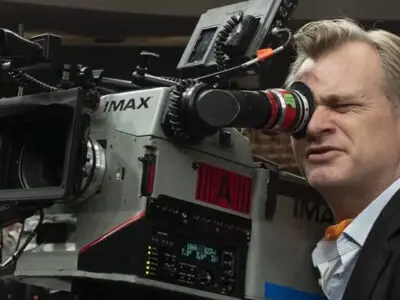 Christopher Nolan looks through an IMAX camera viewfinder.
