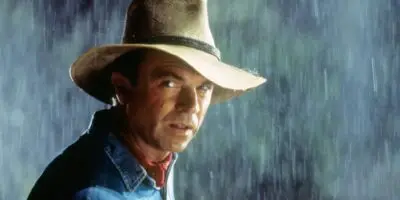 Sam Neill standing in the rain protected by a fedora hat in Steven Spielberg's film Jurassic Park (1993)