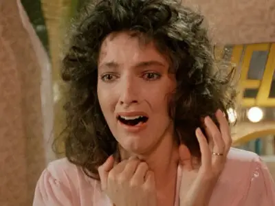 Madolyn Smith shrieks in fright as she sees something off-camera that shocks her in the 1987 film, The Caller.