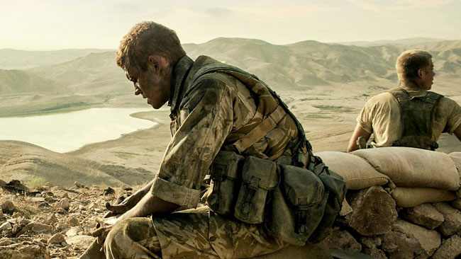 A British soldier in desert military uniform, looking tired and dirty, in the film Kajaki - The True Story.