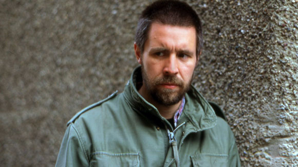 Paddy Considine in a faded green jacket, sporting a trimmed beard and looking angry in Shane Meadow's film, Dead Man's Shoes.
